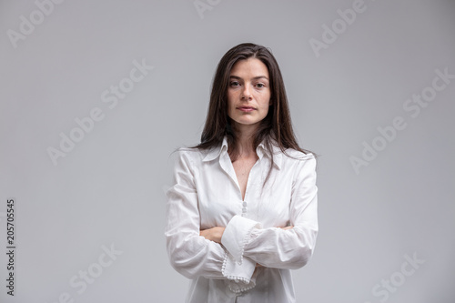 Long-haired woman standing with arms crossed