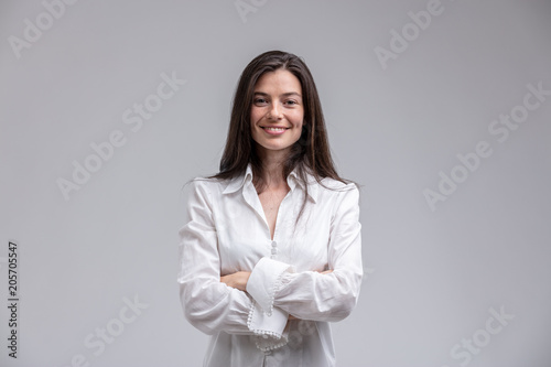 Quadro em tela Smiling woman standing with arms crossed