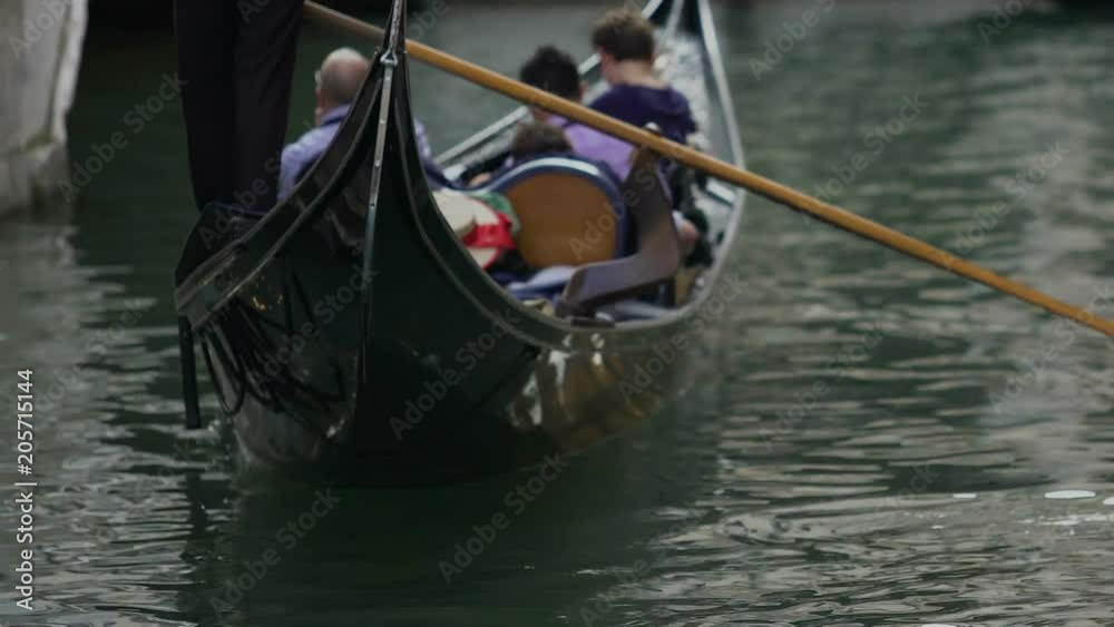 Gondola with tourists floating on water, taxi for tourists in Venice, Italy