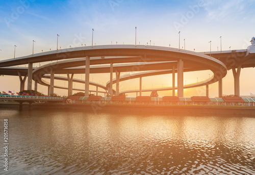 Sunset over highway intersection river front with sunset sky background photo