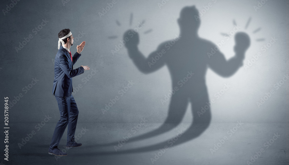 Businessman trying to fight with his unarmed shadow
Businessman trying to fight with his unarmed shadow