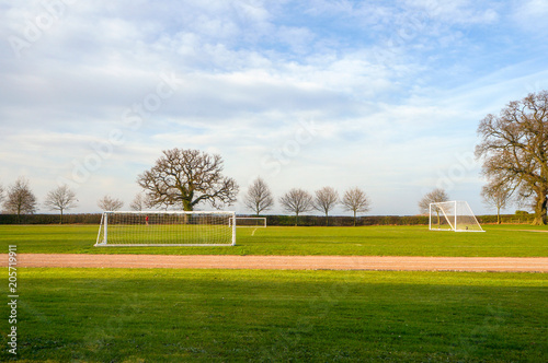 Empty football goalposts in playing fields on a summer morning,
