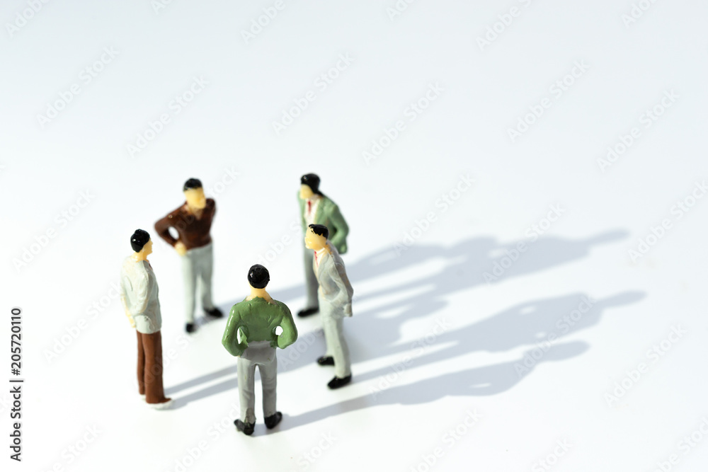 Business leadership, Teamwork power and confidence concept. Miniature people businessman small figure standing with talking on white background. With copy space for your text.