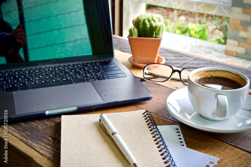 Desk work coffee cup and laptop notebook pen on wooden table