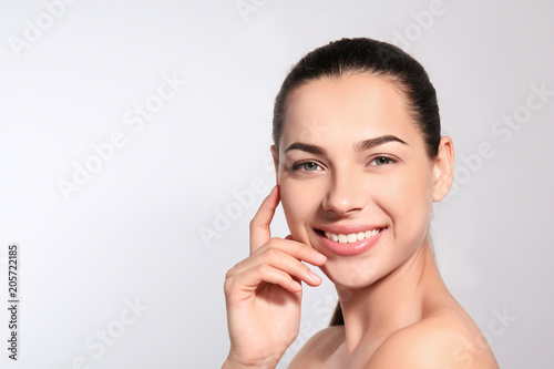 Beautiful woman with perfect eyebrows on light background