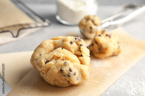 Raw cookie dough with chocolate chips on table, closeup
