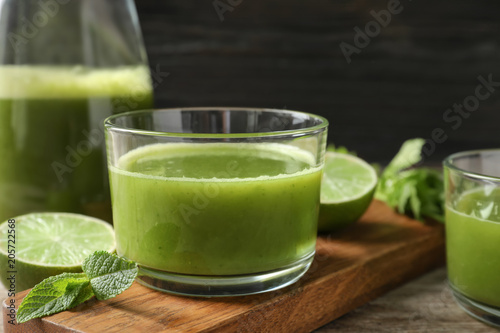 Glass with delicious detox juice and ingredients on table, closeup