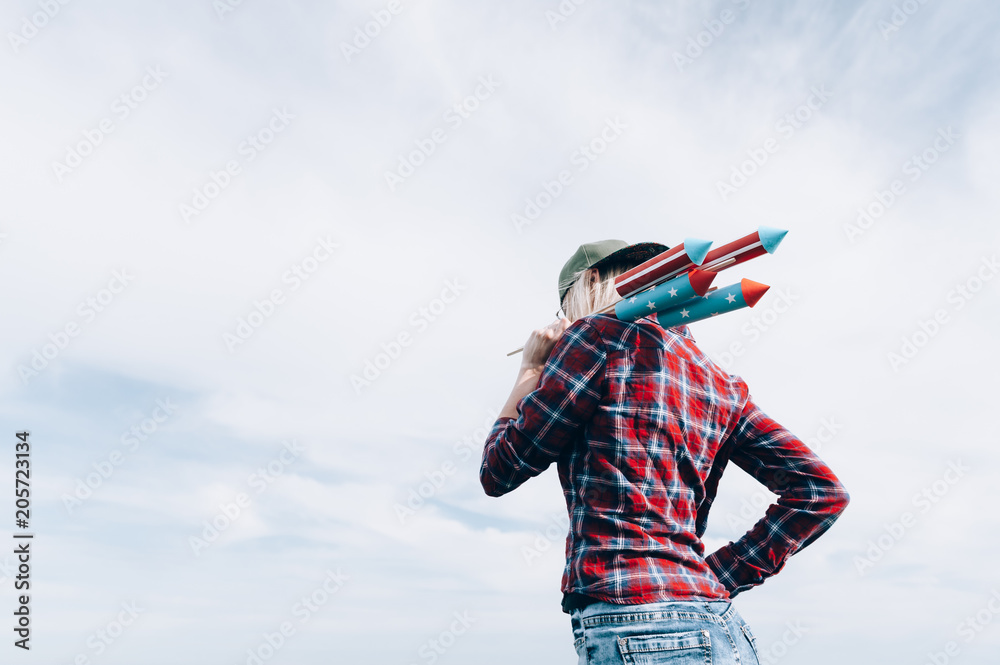 a girl with fireworks in her hands, is preparing to launch missiles in honor of the Independence Day celebration on July 4