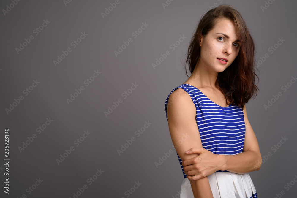 Young beautiful woman against gray background Young beautiful woman against gray background