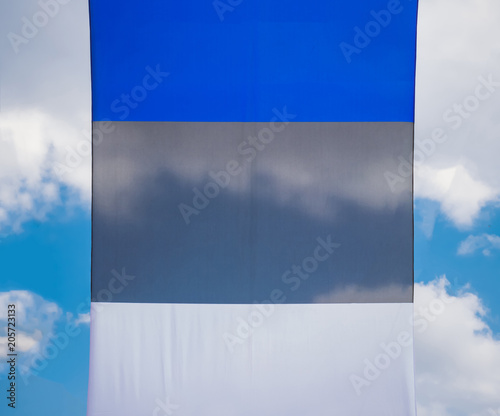flag of Estonia developing in the wind against the sky with clouds