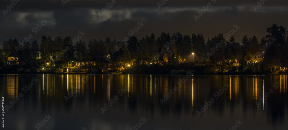 scandinavian village night lights mirrored lake surface