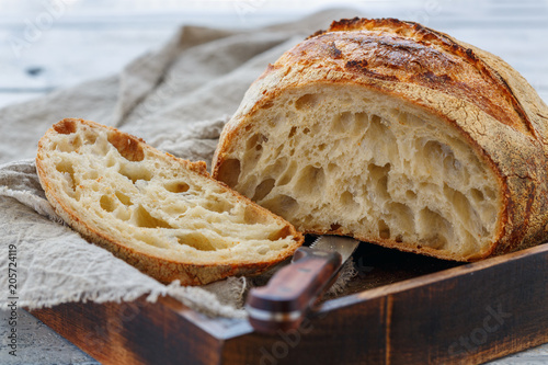 Cut loaf of artisanal wheat bread on sourdough.