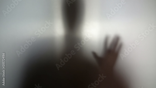 Man needs help, drug addiction, silhouette behind wall asking for help anonymity photo