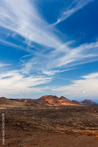 Volcanic crater in the Timanfaya National Park under a blue sky with clouds. Lanzarote  Canary Islands  Spain.