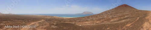 Panoramic view of Playa de las Conchas and volcanic crater under a cloudless blue sky. La Graciosa  Lanzarote  Canary Islands  Spain.