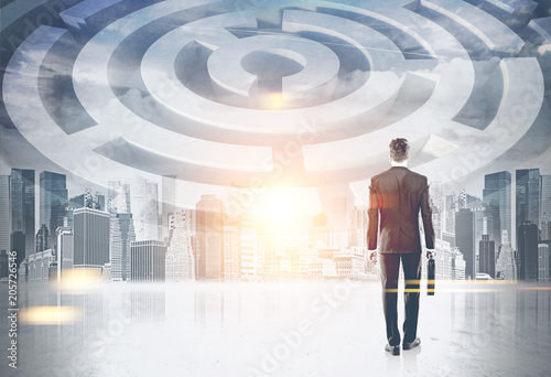 Businessman looking at round maze in city sky © ImageFlow