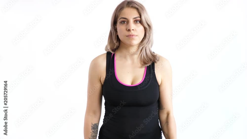 Woman practicing sport with dumbbells over white background in studio Woman practicing sport with dumbbells over white background in studio