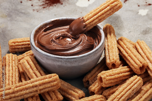 Traditional Spanish dessert churros with sugar and chocolate photo