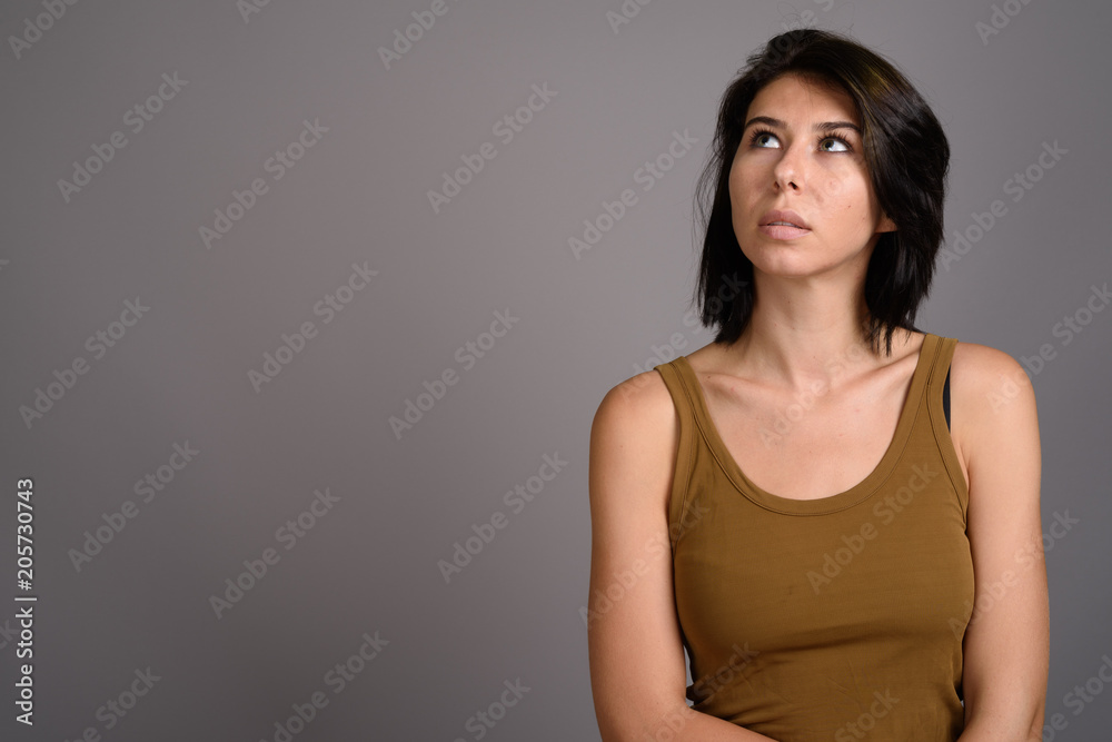 Young beautiful woman against gray background Young beautiful woman against gray background