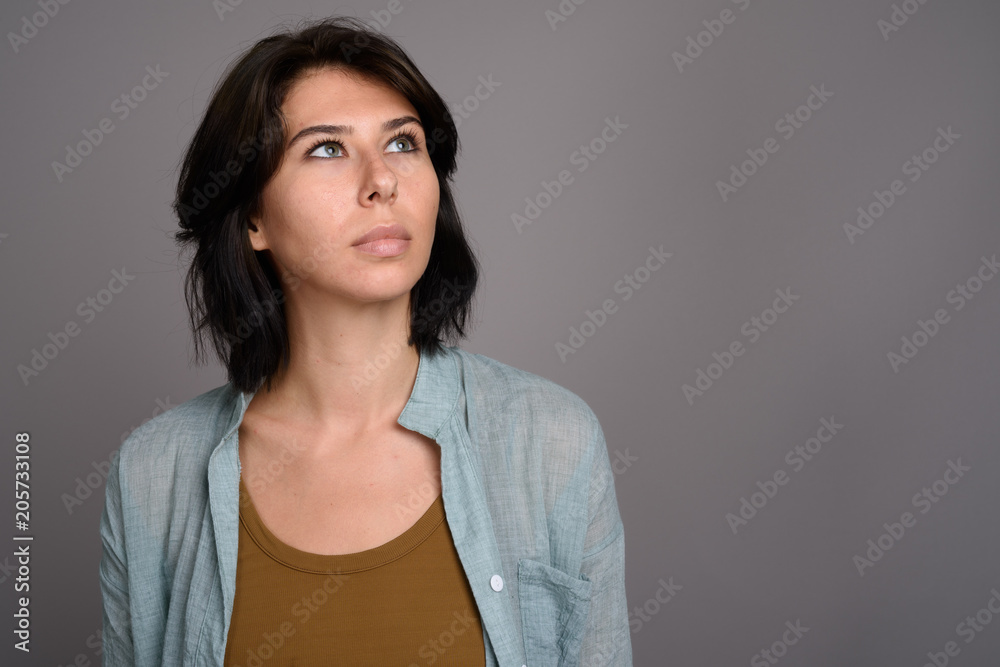 Young beautiful woman against gray background Young beautiful woman against gray background