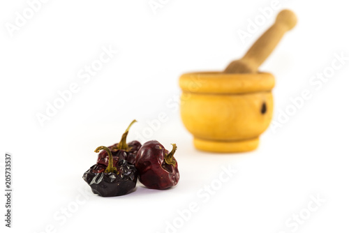 some noras, spanish dry peppers with a mortar behind on white background photo