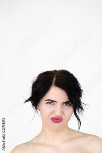 emotion face of aversion. reluctant displeased woman. young beautiful brunette girl portrait on white background.