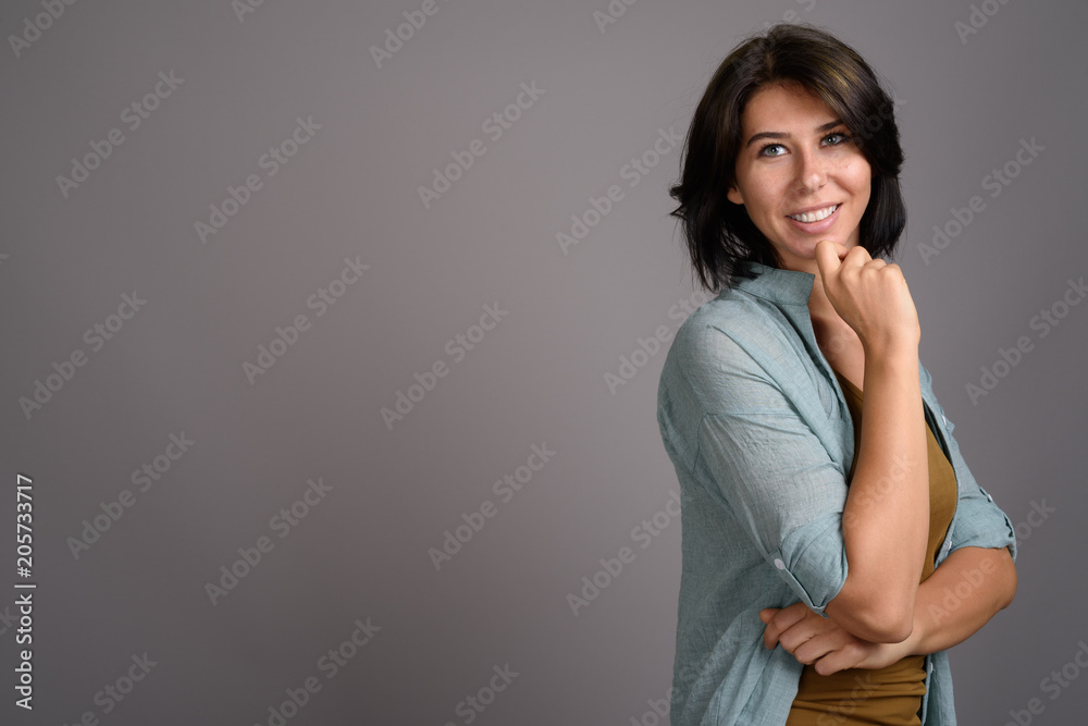 Young beautiful woman against gray background Young beautiful woman against gray background
