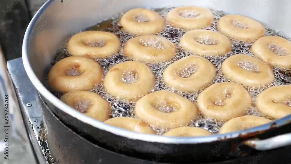 Donut fried maker making machine with stainless steel mold optional, frying sweet and tasty donuts on hot oil in a pan Donut fried maker making machine with stainless steel mold optional, frying sweet and tasty donuts on hot oil in a pan