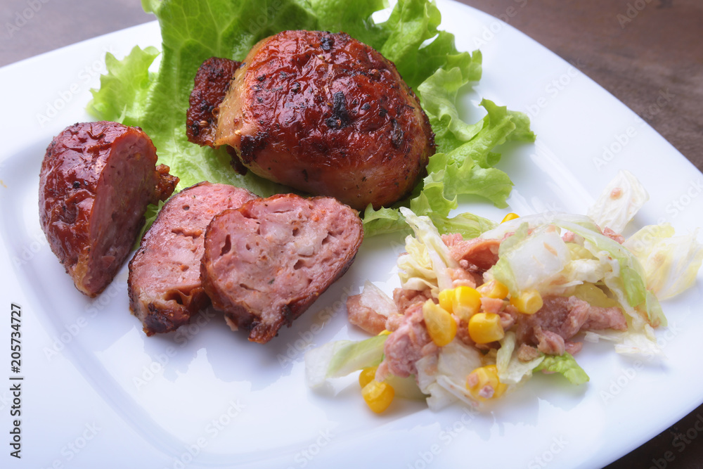 Marinated roaste chicken breasts cooked on BBQ and served with fresh salad on white plate, close-up.