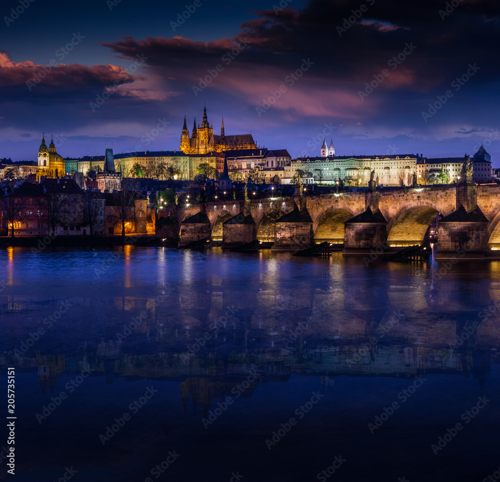 Amazing water reflection of the Charles Bridge (Karluv Most) at dusk on the river. The historic center of Prague, ancient architecture and cultural heritage. Prague. Czech Republic.