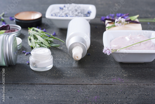 beauty products and lavender on black wooden table
