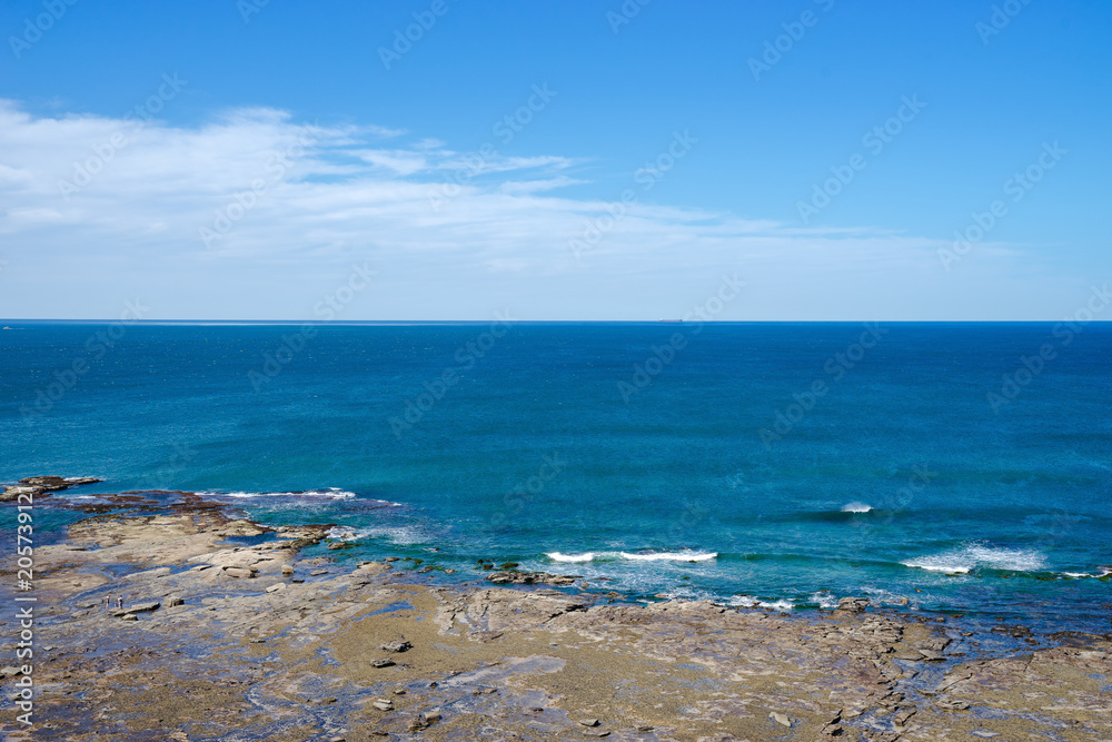 landscape of rock coast line beach deep blue ocean with beautiful clear sky, copy space on ocean