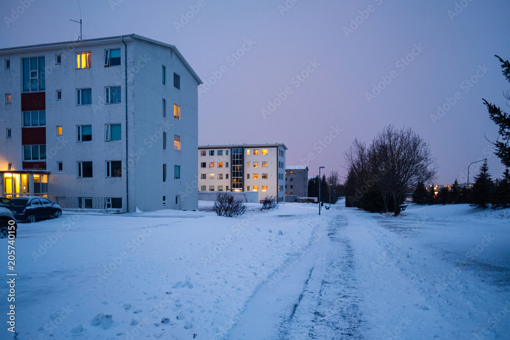 Late evening shot of modern housing covered in snow in Reykjavik, Iceland. Winter scandinavian cityscape with empty streets.
