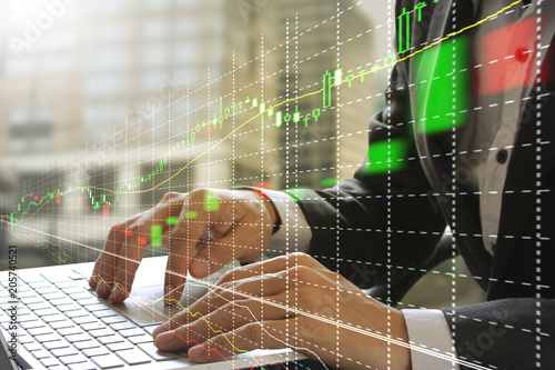 businessman using the laptop with stock market