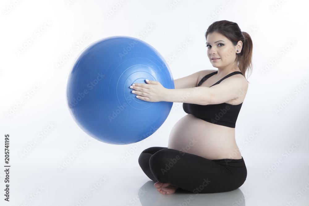 Pregnant woman is doing exercises with gymnastic ball on white background Pregnant woman is doing exercises with gymnastic ball on white background