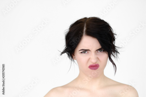 emotion face. bad smell and stinky rancid odour disgust concept. young beautiful brunette girl portrait on white background.