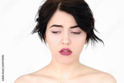 emotion face. downhearted depressed rueful frustrated sad woman. young beautiful brunette girl portrait on white background.