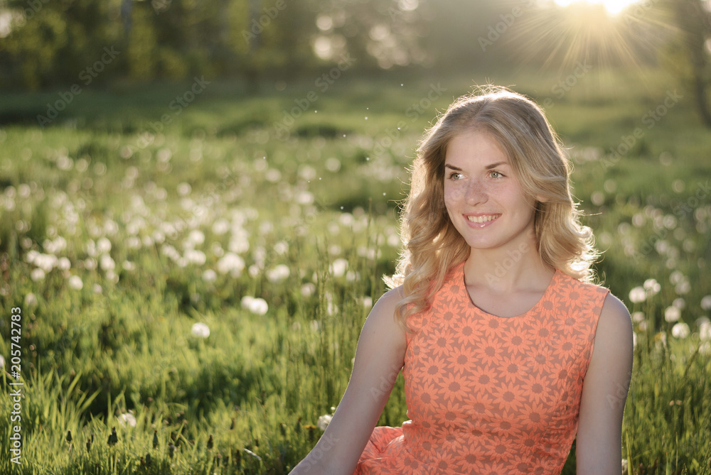 Beauty blond model girl and smelling dandelion flowers. Beauty blond model girl and smelling dandelion flowers.