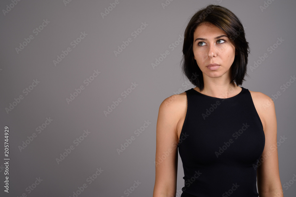 Young beautiful woman against gray background Young beautiful woman against gray background