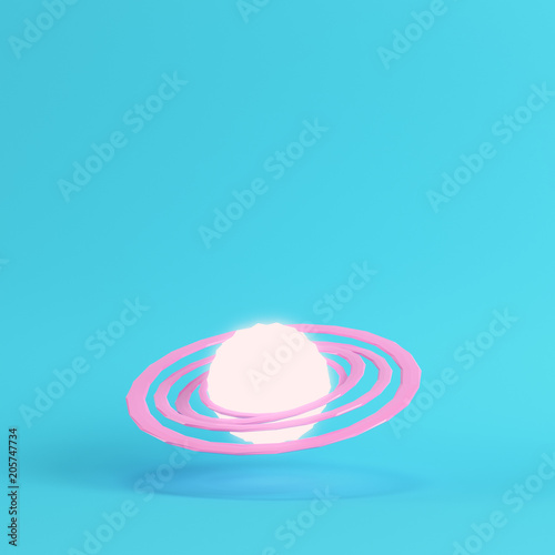Fototapeta Naklejka Na Ścianę i Meble -  Pink abstract glowing planet with rings on bright blue background in pastel colors