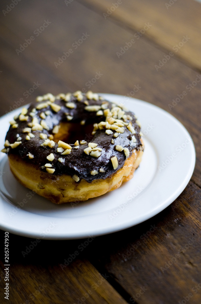 Choco Donut on a white plate and a wooden table 