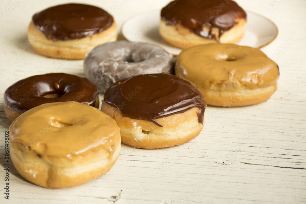 Fresh Donuts on a white wooden background with a coffee cup Fresh Donuts on a white wooden background with a coffee cup
