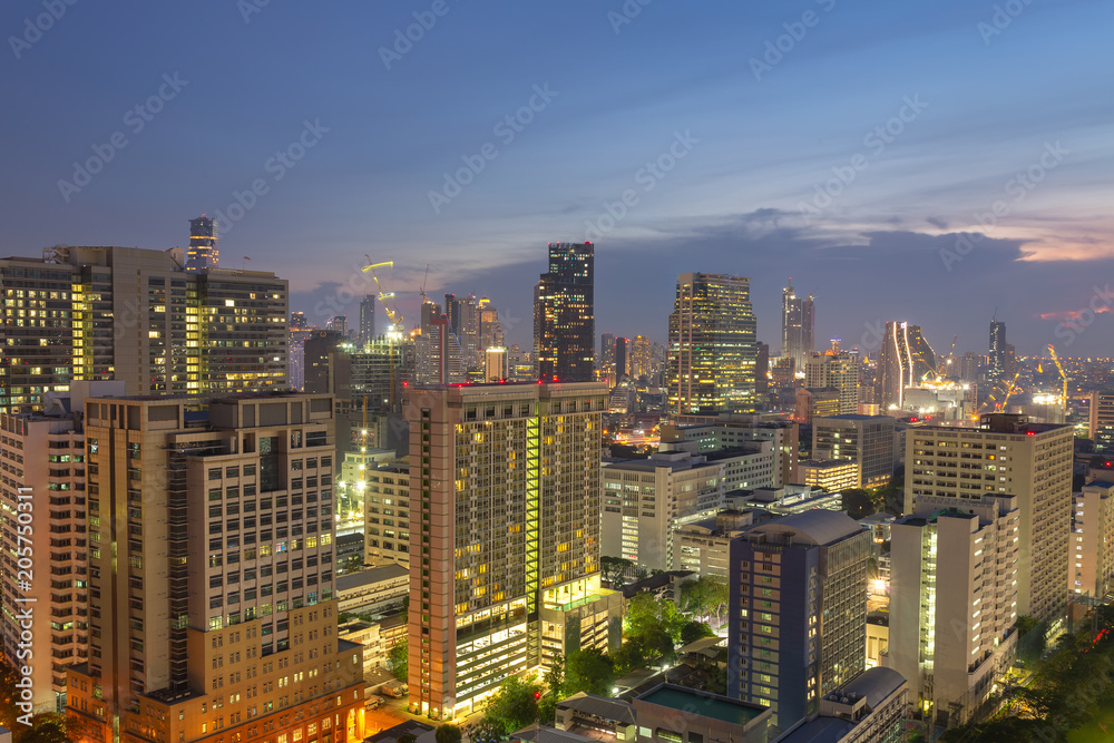 Naklejka premium Night cityscape view of Bangkok modern office business building in business zone at Bangkok,Thailand. Bangkok is the capital of Thailand and also the most populated city in Thailand.
