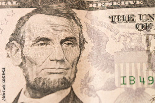 A portrait of President Abraham Lincoln on 5 dollar bill . Close up