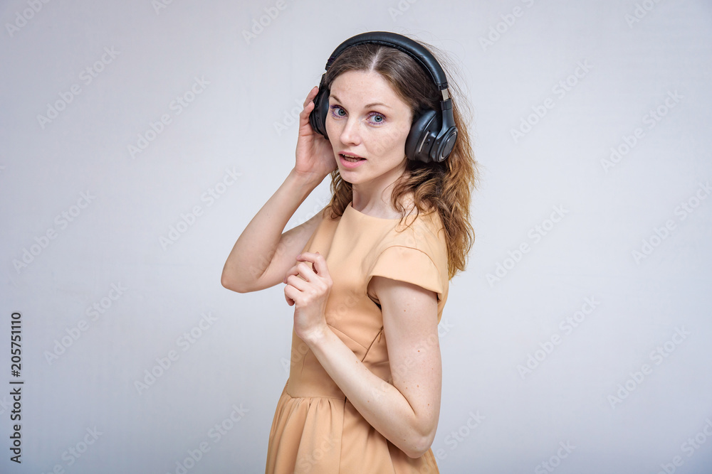 Portrait of beautiful brunette girl on white background listening music with headphones