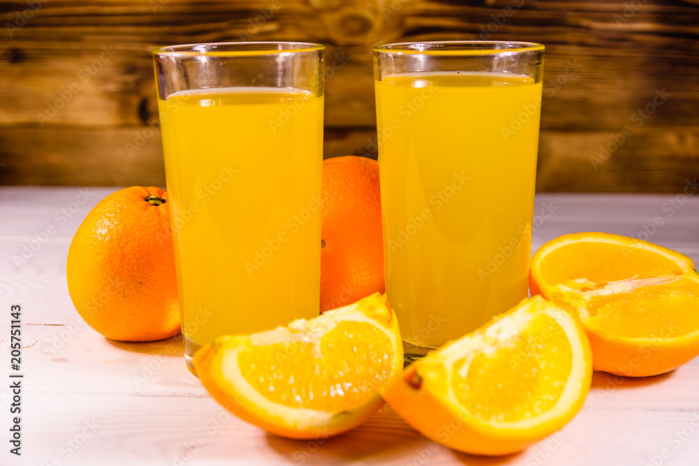 Oranges and glasses with orange juice on a wooden table Oranges and glasses with orange juice on a wooden table