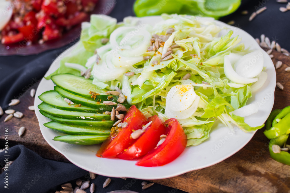 Fresh vegetables salad on plate. Slices of onion rings, tomatoes, cucumber, cabbage and capsicum. Healthy diet. Raw vegan vegetarian food Fresh vegetables salad on plate. Slices of onion rings, tomatoes, cucumber, cabbage and capsicum. Healthy diet. Raw vegan vegetarian food