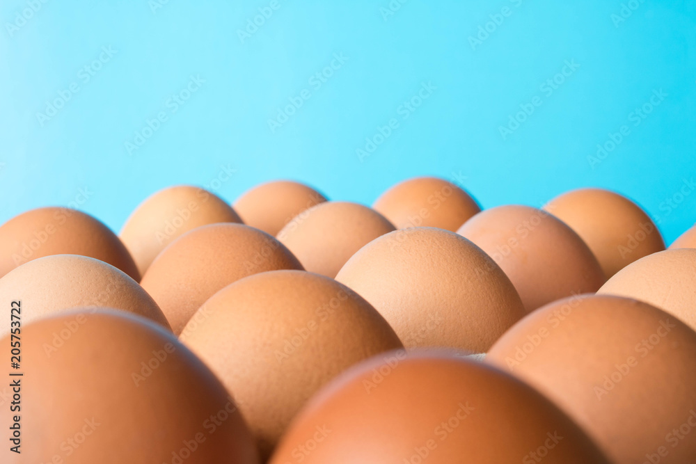 Lots of big chicken eggs on a turquoise background. Close up. Selective focus