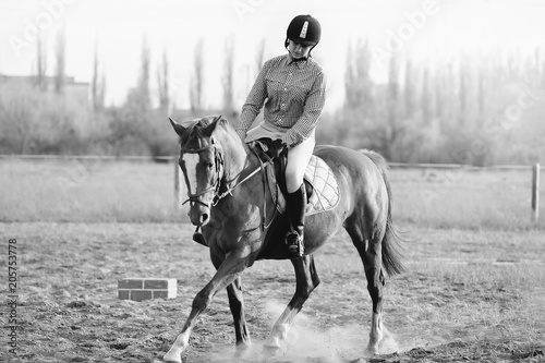 A girl jockey rides a horse