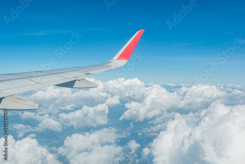 Wing of airplane over beautiful white clouds with bue sky